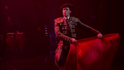 Will dressed in a matador costume, trilling, and singing Elvis