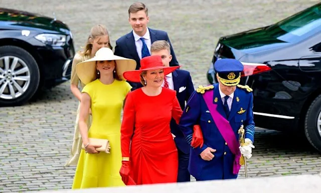 Princess Eleonore wore a ruffled midi dress by Maje. Princess Elisabeth wore a yellow dress. Queen Mathilde wore a red dress