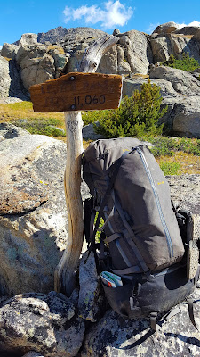 A backpack rests against the sign at Lester Pass in the Wind River Range of Wyoming, USA.