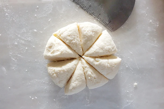 slicing disc of mashed potato flatbread dough into slices