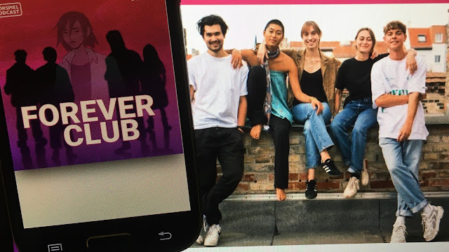 Auf dem Smarthphone links läuft das Hörspiel 'Forever Club' von Jette Volland, im Hintergrund ein Bildschirmfoto der fünf Sprecher*innen von Alek, Bibi, Kat, Mica und Mike (v.l.n.r.)