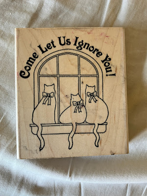 rubber stamp with three cats and the saying Come let us ignore him