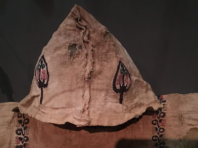 photo of the hood and shoulders of a linen tunic embroidered with leaf patterns 