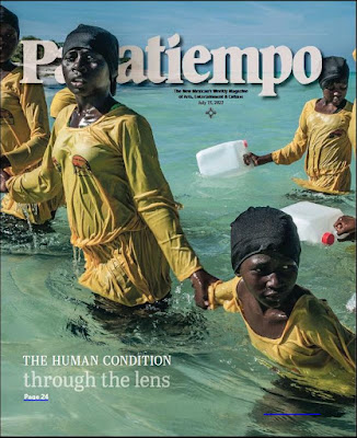 screen shoot of cover of Pasatiempo magazine with photo of women in yellow clothinng emerging from water in Zanzibar