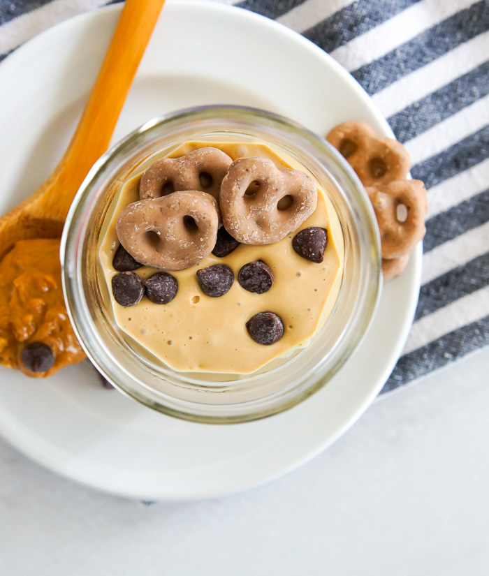 Breakfast Cottage Cheese Peanut Butter Mousse with chocolate chips and peanut butter pretzels in jar with striped napkin