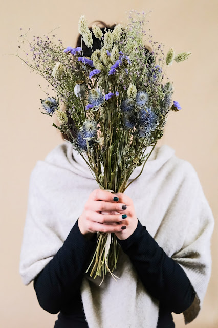 person holding a dried flower bouquet