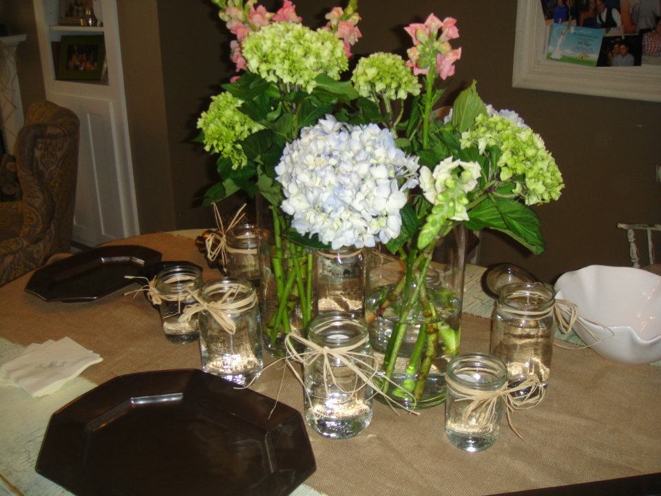 Burlap table runner with different sized mason jars as the center piece