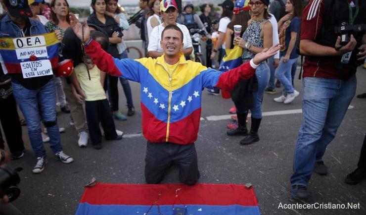 Venezolano orando ante la crisis en su pías