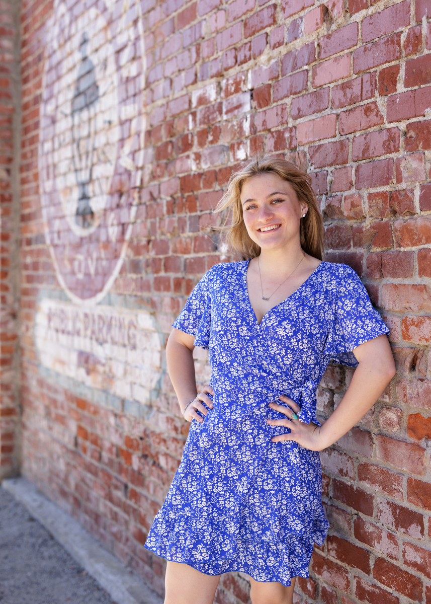 senior girl standing at a brick wall