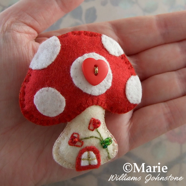 Red and white handmade hand sewn mushroom ornament decoration design with beads and button