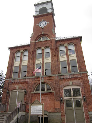 two-story red brick building with a clock tower on top