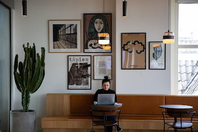 Mujer sentada delante de su portátil en una cafetería