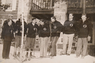A photograph showing a group of men standing together in skis.