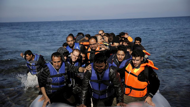 Refugees and migrants arrive on a raft on the Greek island of Lesbos,