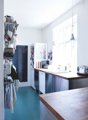 Danish kitchen with stainless appliances, blue floor and silver pendant lights