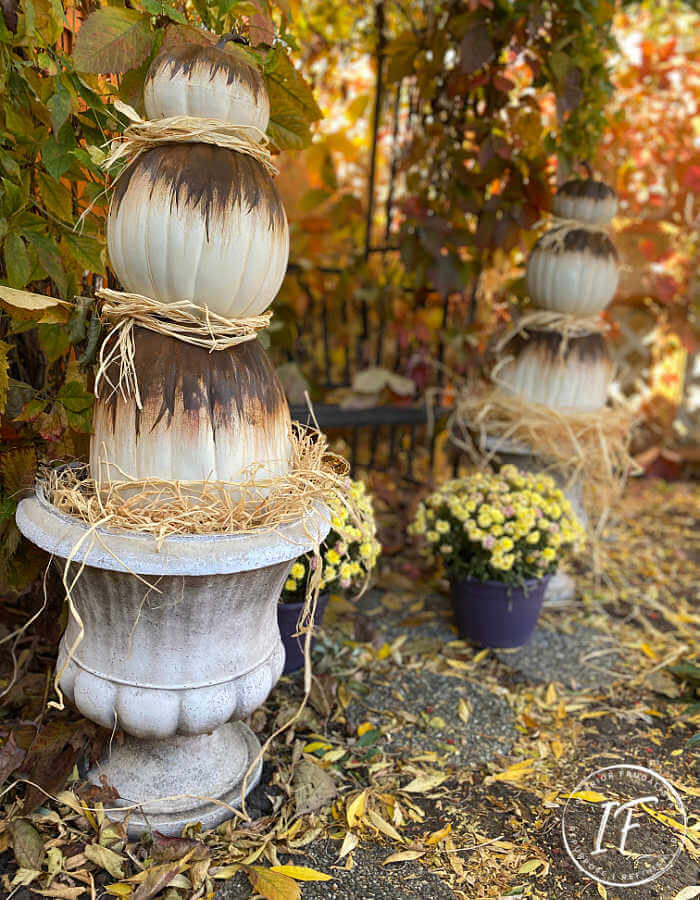 Unique Rust Paint Dripped Abstract Pumpkin Topiaries with white artificial stacked pumpkins and rust activated paint to decorate outdoors for fall.