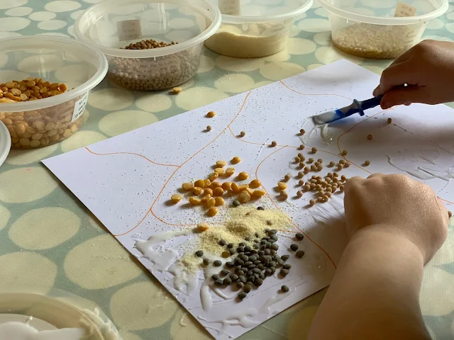 Toddler gluing lentils and couscous onto card in sensory art idea