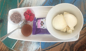 Children dessert, ice cream with toffee sauce, buttons and raspberries