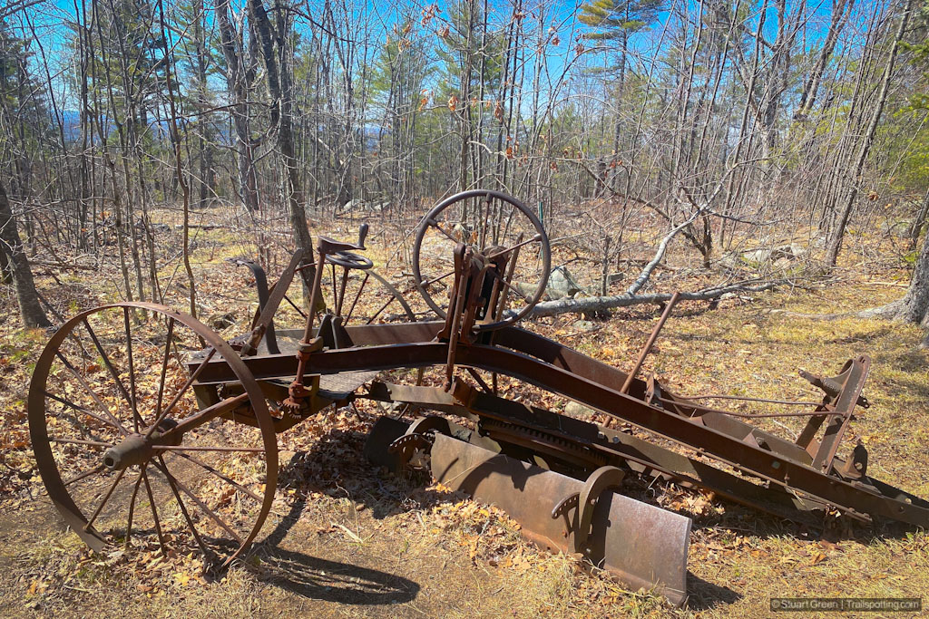 rusted frame of an old road grader
