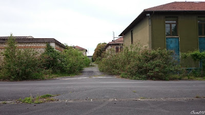 Bâtiments abandonnés base militaire envahis par la végétation