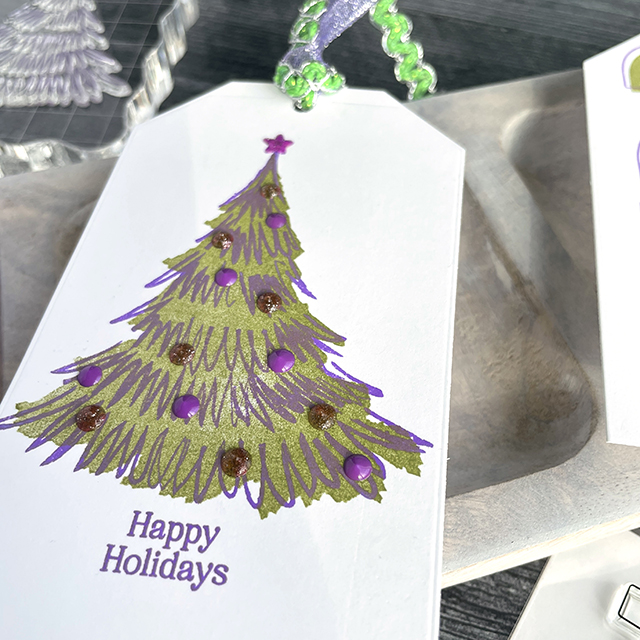 Bright Christmas tags made with: Scrapbook.com nested tags, bold numbers large stamp, christmas trees stamp, winter wishes and spruce sprigs stamp, pops of color in deep orchid lavender luster and pixie; Tim Holtz distress ink peeled paint, distress oxide wilted violet