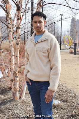 Carter in a park wearing a beige quarter snap top