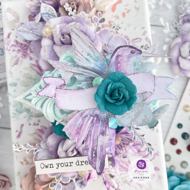 Mixed media canvas featuring a hummingbird and paper flowers from the Prima Marketing The 3 Girls Tale collections Lost in Wonderland, Postcards from Paradise and Aquarelle Dreams.