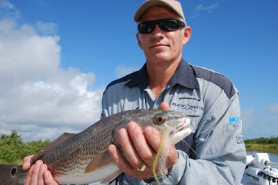 man with redfish on fly