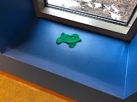 one green flannel sheep next to low window