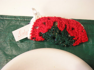 Granny square Christmas stocking used as a placecard holder at a dinner table.