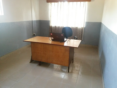 Et kontor med en enslig pult, stol og laptop midt i rommet