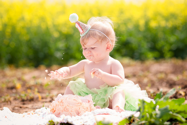 Family session including one-year cake smash in an Oklahoma canola field by Michelle Valantine Photography.