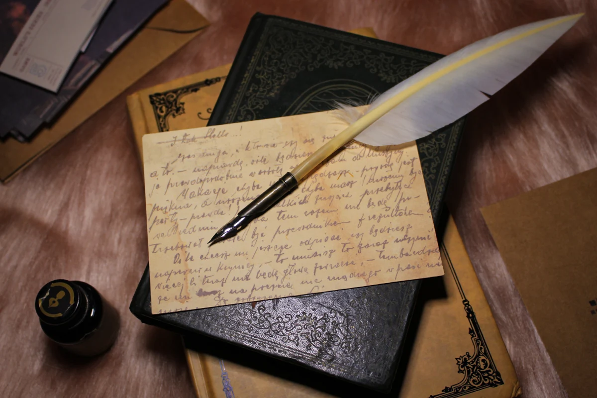 a quill on top of a small old journal