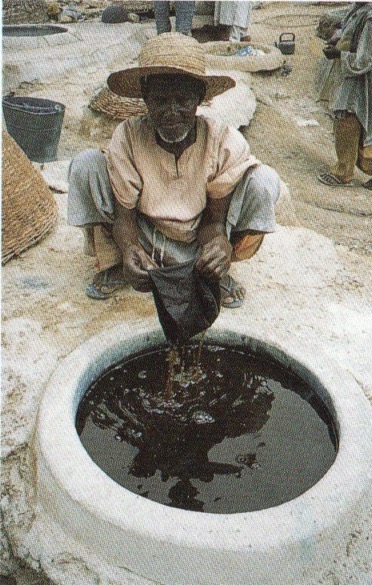 Cloth being dyed in an indigo pond