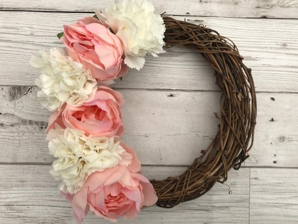 Rattan wreath with flowers along one side