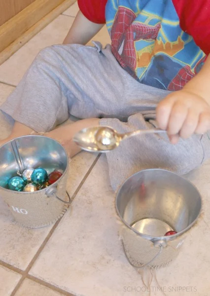 scooping christmas bulbs for fine motor skills development