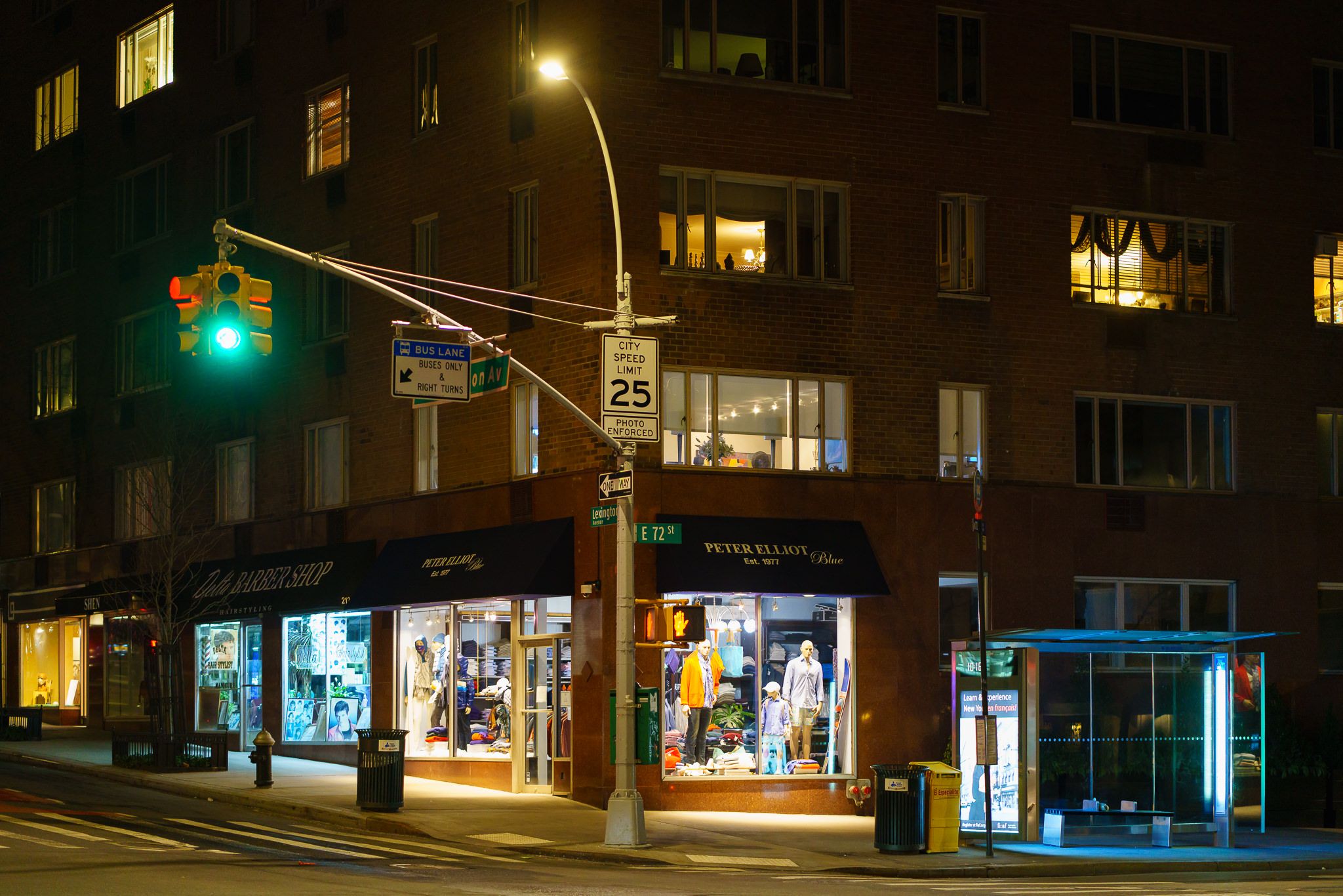 a photo of shops at a new york city intersection at night