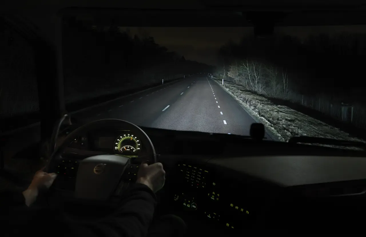 Motorista de caminhão dirigindo em uma estrada escura