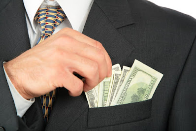 Man in suit with $100 bills in his dress suit pocket