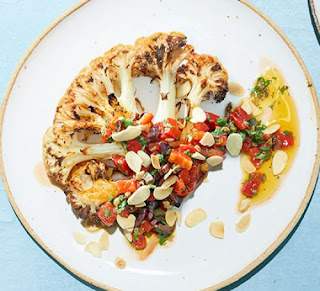 Cauliflower steaks on a plate with red pepper and olive salsa