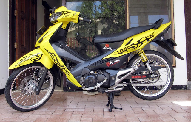 Foto Modifikasi Honda Revo dengan stiker strip hitam dibalut airbrush pada bodi motor dengan warna yang jreng yakni warna kuning tak lupa shockbreaker pun juga diwarna kuning untuk menyelaraskan warna pada bodi motor knalpot menggunakan merk R9 racing serta velg berukuran 17 inci dan menggunakan rem cakram jok berwarna hitam pekat