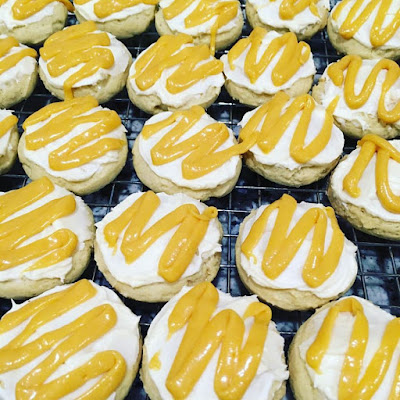 Morir Soñando Cookies: close-up photo of a group of orange cookies with vanilla buttercream icing and a drizzle of orange glaze