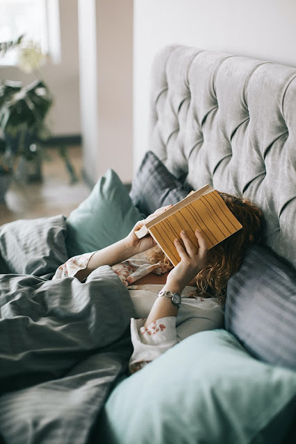 https://www.pexels.com/photo/woman-covering-face-with-book-on-bed-1524232/