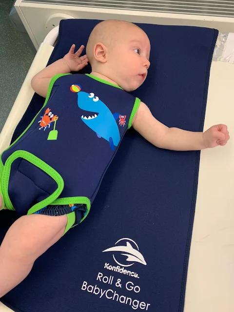 Baby Boy on the Konfidence roll & go neoprene changing mat in a Babywarma baby wetsuit to keep warm and double swimming nappy