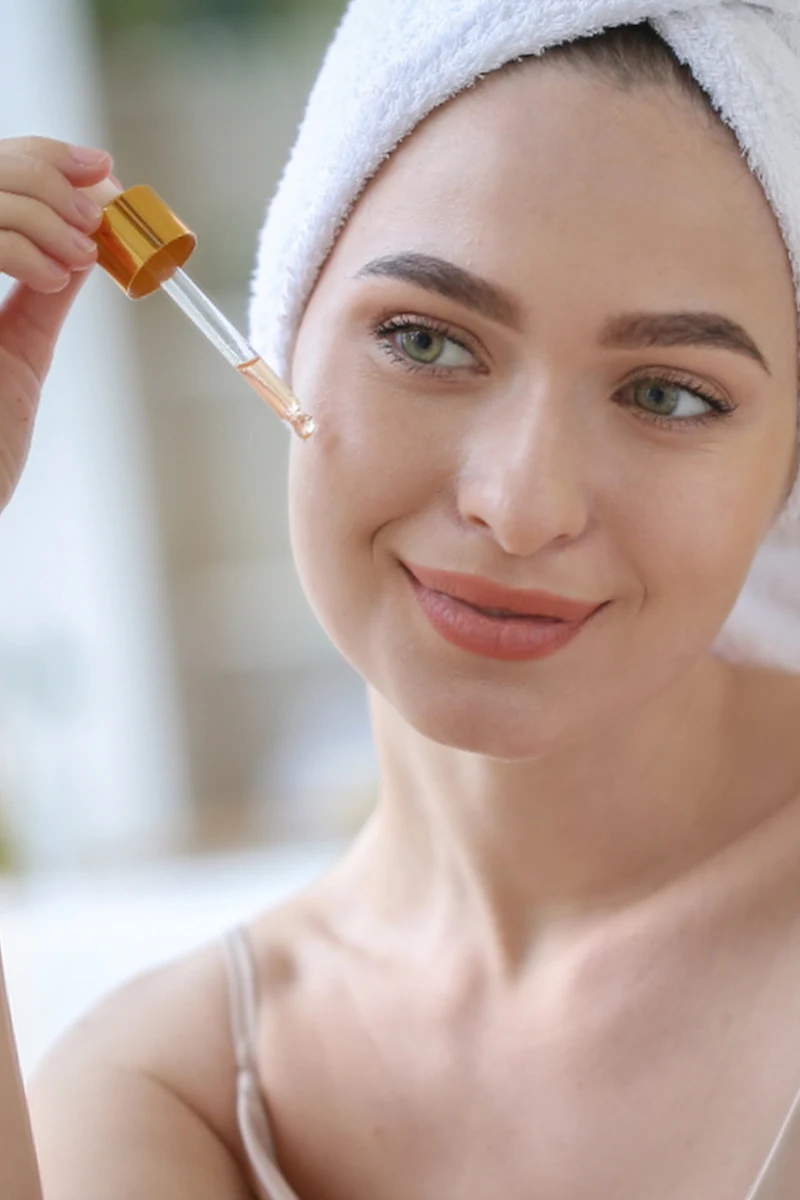 woman applies hyaluronic acid on to her face