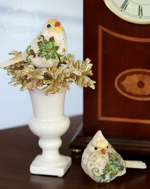 Christmas birds on glittery gold ornament just on top of a vase.
