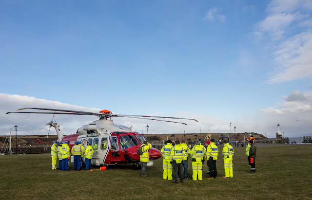 Photo of lifeboat and Coastguard rescue teams with the Coastguard helicopter