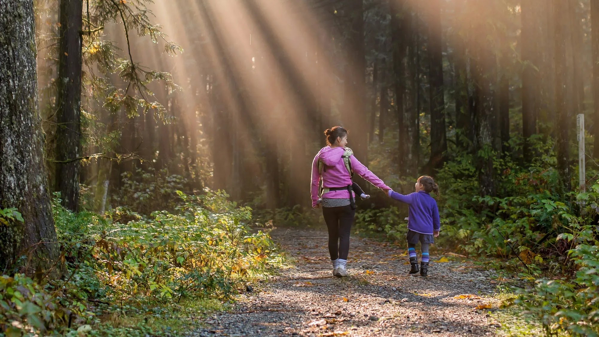 Mother talking with her daughter and walking into a forest