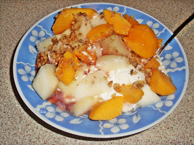 Πιάτο βαθύ με γαλάζια σχέδια που έχει κομμάτια φρούτων,ροδάκινο,πεπόνι,μήλο,καρύδια,γιαούρτι και γλυκό κουταλιού.