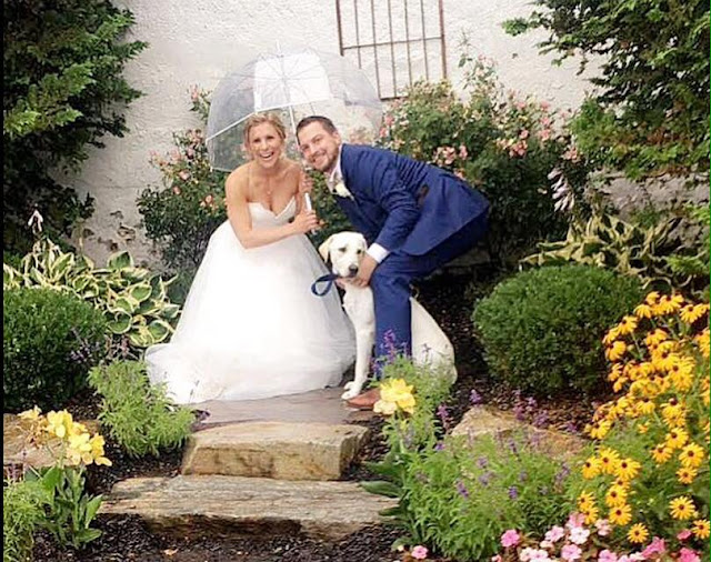 bride, groom and dog in garden
